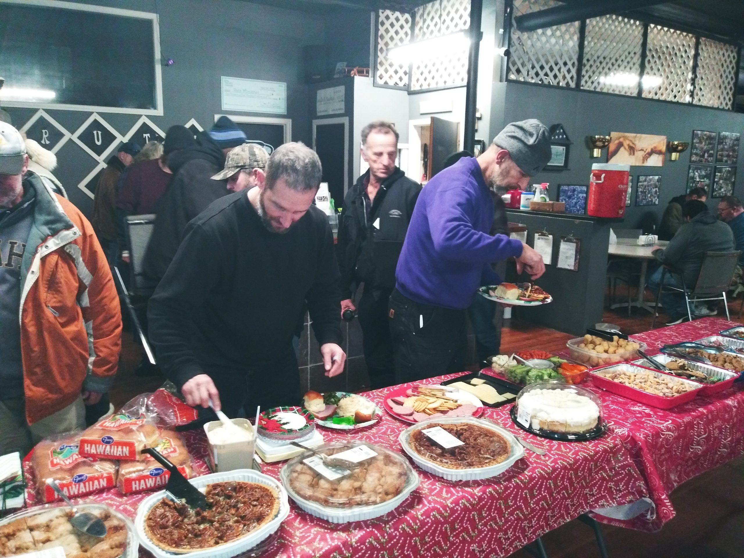 A group of people standing around a table with plates.